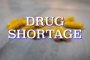 Blurred background of prescription medicine with the words Drug Shortage in the foreground