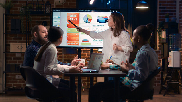 Company employee explaining analytics research results in business meeting, showing statistics data on digital board. Marketing revenue report presentation, colleagues team planning sales strategy - Powered by Adobe