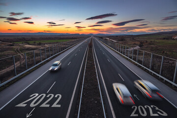 Driving on open road at beautiful sunny day to new year 2023. Aerial view of travel and transportation on highway. 