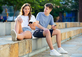 Fototapeta na wymiar Two teenagers chatting on their smartphone on walking