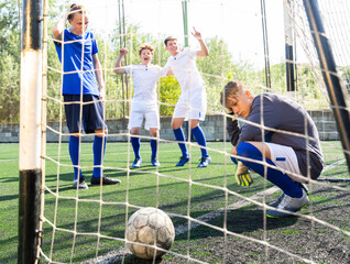 Goalkeeper missed the ball into the goal. Young teen soccer game