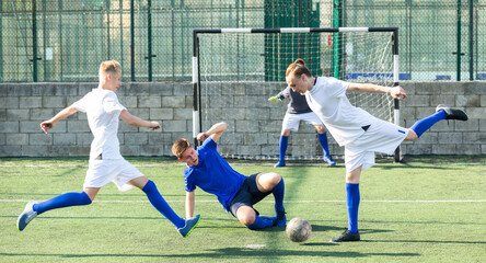 Young football players fighting for ball in middle of field