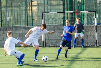 Youth football player kicking ball in direction of goal
