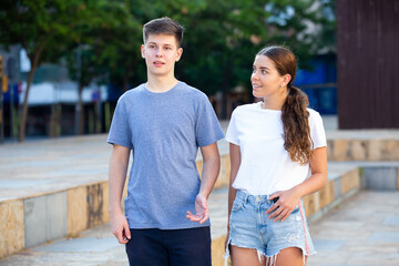 Portrait of happy girl and boy teenagers walking outdoors