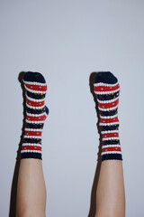 legs in christmas socks raised up on grey