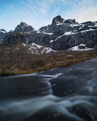 Plakat Mountain peaks rise above flowing stream, Lofoten Islands, Norway