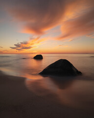 Fototapeta na wymiar Sunset over coastal rocks at Myrland beach, Lofoten Islands, Norway