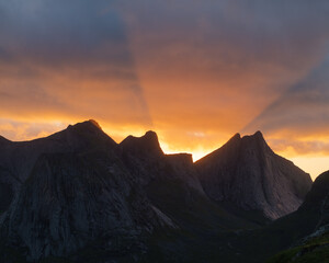 Clouds glow at sunset behind mountain peaks, Lofoten Islands, Norway