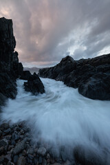 Incoming wave flows over rocky coastline, Lofoten Islands, Norway