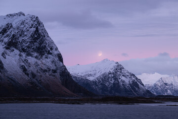 Fototapeta na wymiar Moon over mountain peaks in December twilight, Lofoten Islands, Norway