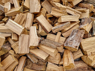 Chopped down tree trunks, firewood stacked in a storage yard, for heating in winter. Selective focus
