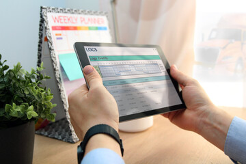 Safety manager is showing to Truck driver  electronic logbooks on a tablet