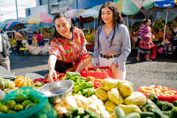 Madre e Hija van al mercado local a comprar vegetales frescos.  