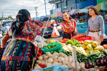 Mujeres en mercado local a comprar vegetales frescos.  