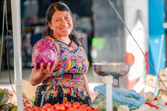 Mujer Latina En Un Puesto De Verduras En El Mercado Sostiene En Sus Manos Un Repollo .