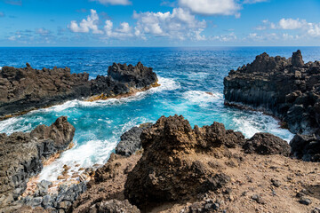 Fototapeta na wymiar Cove with clear, vivid blue water in volcanic coast of Maui, Hawaii