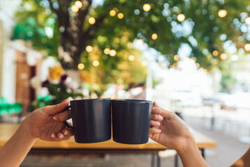 Closeup image of a people clinking coffee cups together in cafe