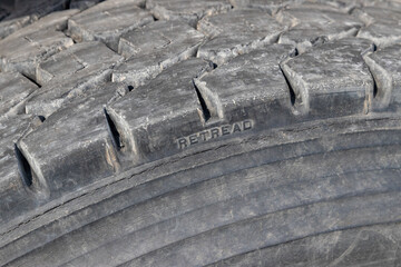 Retread tire on farm truck. Rubber recycling, trucking industry, tire wear and safety