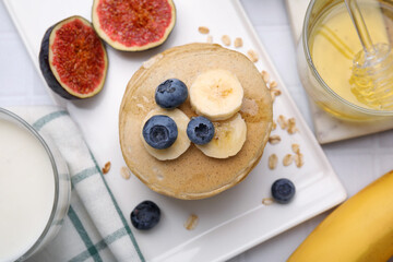 Tasty oatmeal pancakes served on white table, flat lay