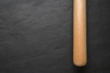 Baseball bat on black background, top view with space for text. Sports equipment