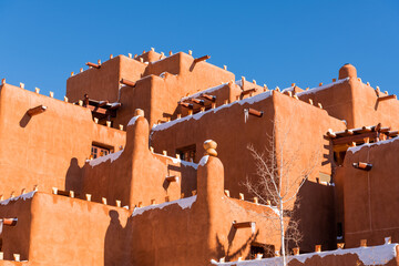 Obraz premium Winter scene of snow-covered adobe pueblo style building in Santa Fe, New Mexico