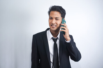 Young Asian Man is confused and shocked when calling in the phone. Indonesian man wearing a black suit.