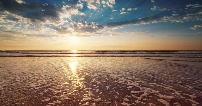 Happy New Year 2023 text in sand, ocean sunrise on the beach shore. Golsen sea sunset.