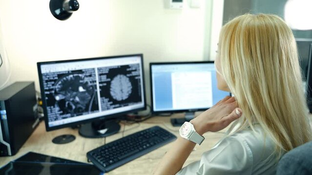 Professional neurologist looking at MRI image of patient’s head. Doctor analyzing CT scan to establish diagnosis.