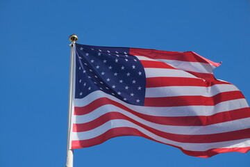 US flag soars into blue sky