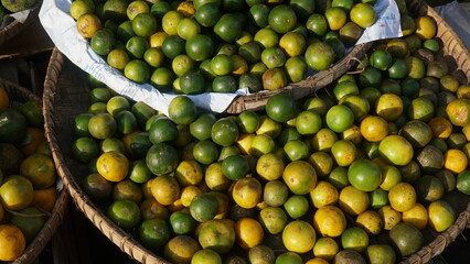 Lime or kaffir lime on a bamboo basket in a traditional market. Focus selected
