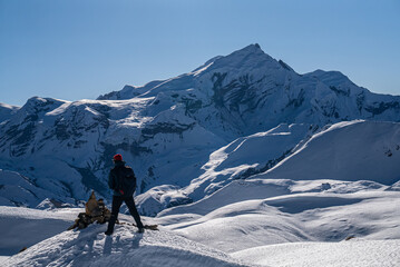 Trekker looking at view of snowy mountrain range on the Annapurna Circuit Trek, Nepal