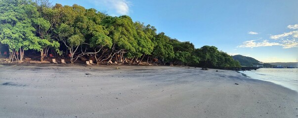 a sandy beach next to a body of water