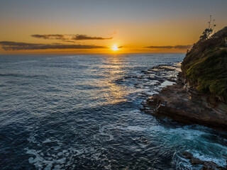 Fototapeta premium Sunrise over the ocean with rocks