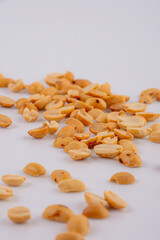 Heapof roasted peanuts close up on a white. Isolated.