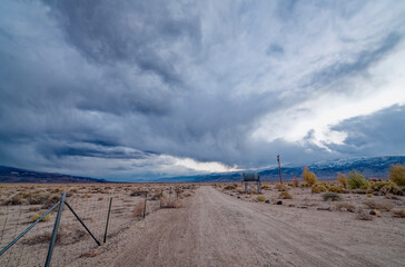 Storm clouds gather over a dirt road in the desert in western Nevada, USA