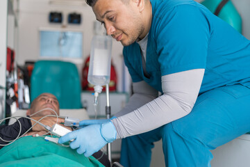 Doctor checking a patient's pulse in an ambulance © Guillermo Spelucin