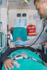 Vertical photo of a doctor checking a patient's heartbeat in an ambulance