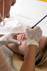 The master draws a sketch before the lip permanent procedure with a brush. 