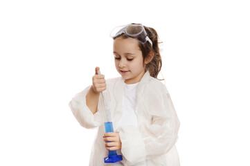 Smart little girl, student chemist-scientist in lab coat, dripping few drops of reagent from...