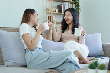 Obraz na płótnie Canvas lgbtq, LGBT concept, homosexuality, portrait of two Asian women posing happy together and showing love for each other while having coffee at the dining table