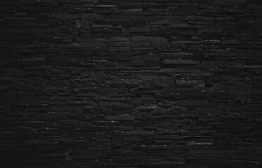 Pattern of black brick wall style. Modern building exterior backdrop. Dark texture background. Rough surface stone block.