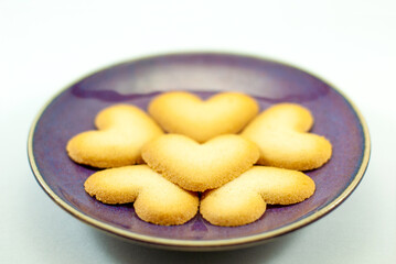Heart-shaped biscuits on a ceramic plate, selective focus, Valentine's day concept.