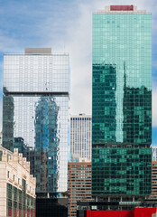 Modern glass and steel skyscrapers in vibrant teal, green, and blue colors