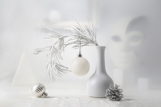 Monochrome Christmas still life: pine branch in a white vase, Christmas decorations, abstract