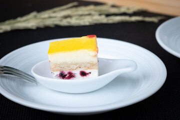 A piece of yellow fruit cake in a spoon and ready to eat.