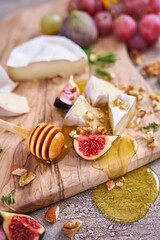 Sliced Camembert or brie cheese on wooden cutting board at domestic kitchen