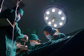 A team of professional doctors perform surgery in a hospital, a group of surgeons working in the...