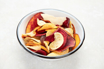 Vegetable organic chips made from potatoes, beets and carrots in a white plate for a snack, top...