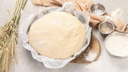 Raw dough pastry in a bowl on neutral background.