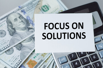 Focus on solutions text card on a clip to a sheet with numbers, business concentration